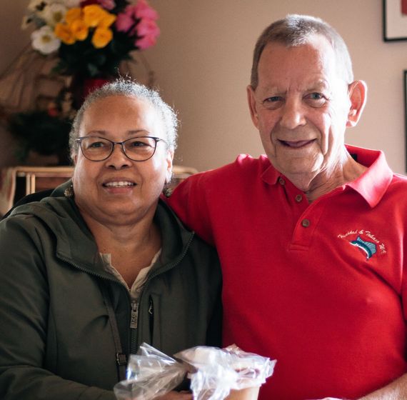 smiling elderly man and woman in apartment