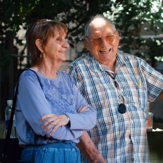 elderly man and woman standing outside talking