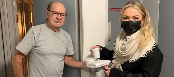 volunteer delivering a meal to a senior