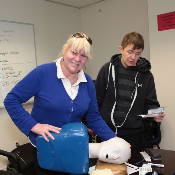 smiling woman practicing first aid and CPR