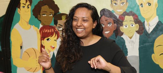 smiling young woman in front of a mural