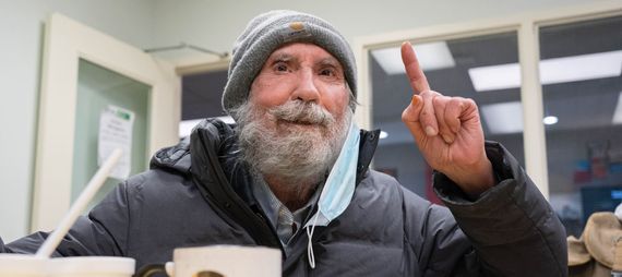 elderly man in Corner Drop-in raising a finger