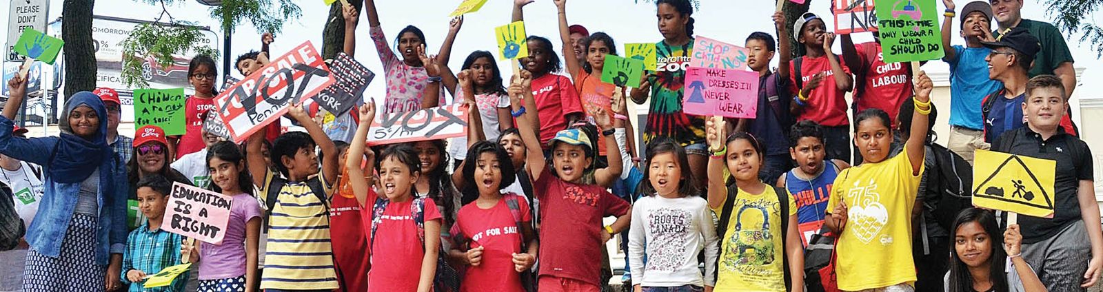 group of children and caregivers holding protest signs