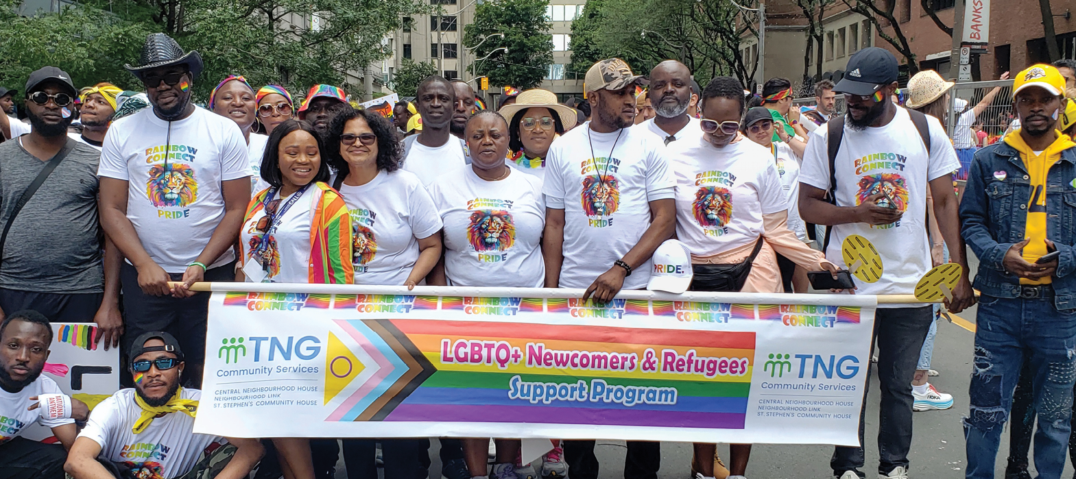 group of people wearing white Rainbow Connect signs and holding a banner with the text "LGBTQ+ newcomers and refugees support program"