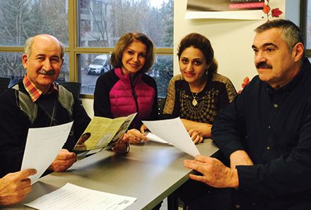 group of people holding papers at a table