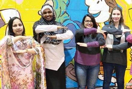 women posing against a wall mural