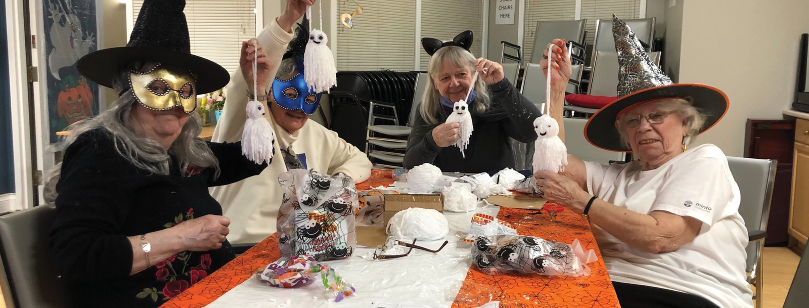 seniors in supportive housing dressed up for Halloween and doing arts and crafts